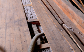 Altbau-Dachboden mit Holzbalkendecke, in die der Dämmstoff Zellulose eingeblasen wird